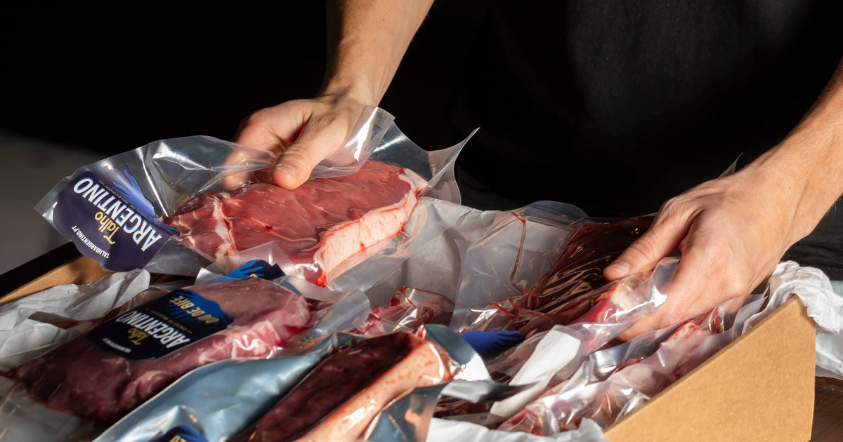 Mains rangeant des morceaux emballés sous vide dans une boîte d'expédition